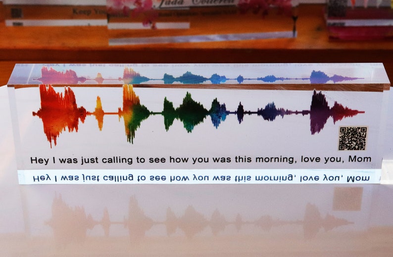 May include: A clear acrylic block with a rainbow-colored sound wave graphic and the text "Hey I was just calling to see how you was this morning, love you, Mom" and a QR code.
