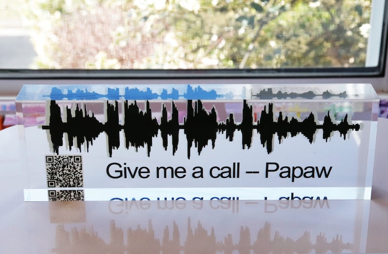 May include: A clear acrylic block with a black sound wave graphic and the text "Give me a call - Papaw". A black and white QR code is also visible on the block.