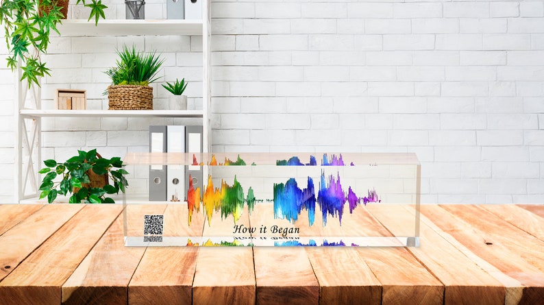 May include: A clear acrylic block with a colorful sound wave design inside. The sound wave is a rainbow of colors, with red, orange, yellow, green, blue, indigo, and violet. The text "How it Began" is printed below the sound wave.