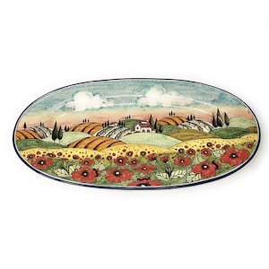 Könnte beinhalten: Eine ovale Servierplatte aus Keramik mit handbemaltem Motiv einer toskanischen Landschaft. Die Szene zeigt sanfte Hügel, ein kleines Haus, Bäume und ein Feld mit roten Mohnblumen.