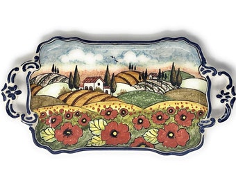 May include: A ceramic serving tray with a hand-painted scene of a Tuscan landscape. The tray features rolling hills, a small village, and a field of red poppies. The tray has two handles and a blue and white border.