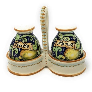 May include: Ceramic salt and pepper shakers with a handle, decorated with lemons and green and blue floral designs. The shakers are labelled "Sale" and "Pepe".
