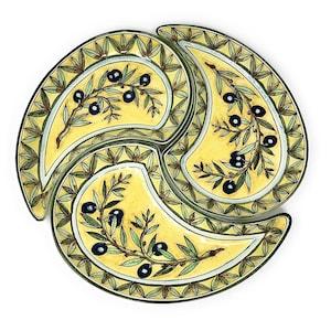 Może przedstawiać: Trójczęściowa ceramiczna tacka serwująca z żółtym tłem i zielonymi wzorami gałązek oliwnych. Każda sekcja ma kształt półksiężyca i zawiera czarne oliwki na gałązkach.