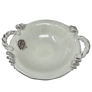 Può includere: Scodella in ceramica bianca con due manici a forma di corda. La ciotola ha un bordo leggermente rialzato e una finitura liscia e lucida.