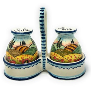 May include: A ceramic salt and pepper shaker set with a handle. The shakers are decorated with a painted landscape scene and the words "Sale" and "Pepe".