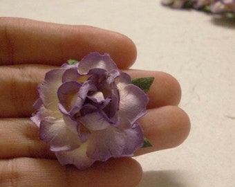 May include: A single, purple paper flower with a white center and green leaves. The flower is delicate and has a layered, ruffled appearance.