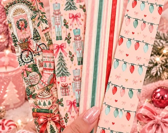 May include: Four rectangular paper bookmarks featuring Christmas themes. One shows a pink door with a bicycle, one has nutcrackers and bows, one features vertical stripes in red, green, and cream, and one displays a pattern of red and teal light bulbs.
