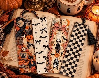May include: Four rectangular bookmarks with tassels. The first features a crow, pumpkins, a candle, and a cat. The second has a white background with black bows and bats. The third shows hanging bats and a pink bow. The fourth has a black and white checkerboard pattern.