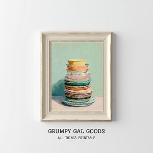 May include: A framed print featuring a stack of colorful plates and bowls. The artwork showcases a variety of patterns and colors, including yellow, orange, pink, and blue. The text "GRUMPY GAL GOODS ALL THINGS PRINTABLE" is at the bottom.