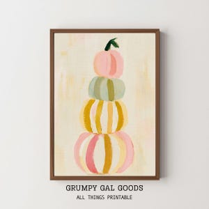 Puede incluir: Una impresión artística enmarcada que muestra una pila vertical de cuatro calabazas pintadas en tonos rosa, verde salvia, amarillo y blanco con patrones de pinceladas. El texto GRUMPY GAL GOODS ALL THINGS PRINTABLE aparece debajo.