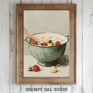 May include: A framed print depicting a still life of raspberries in a green colander with a wooden spoon. The artwork has a vintage aesthetic, with the text "GRUMPY GAL GOODS ALL THINGS PRINTABLE" at the bottom.