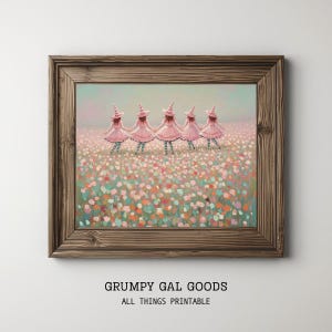 May include: A framed wall art print featuring five figures in pink dresses and pointed hats holding hands in a field of colorful flowers. The text GRUMPY GAL GOODS ALL THINGS PRINTABLE is printed in black below the wooden frame.