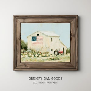 May include: A framed wall art print featuring a painting of a white barn with an American flag painted on its side, situated in a field with a red tractor. The frame is made of dark brown wood with a visible grain, surrounding the rectangular artwork.