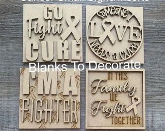 May include: Unfinished wooden sign kit with four square and circular cutouts. The signs feature phrases like "Go Fight Cure," "Someone I Love Needs a Cure," "I'm a Fighter," and "In This Family We Fight Together." Includes ribbon symbols.