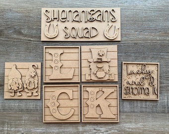 May include: Wooden craft cutouts for a St. Patrick's Day sign. The cutouts include the letters "LUCK", a gnome, two gnomes, and a sign that says "Shenanigans U Squad U".