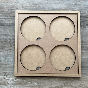 May include: A wooden frame with four circular cutouts. The frame is light brown and has a smooth finish.