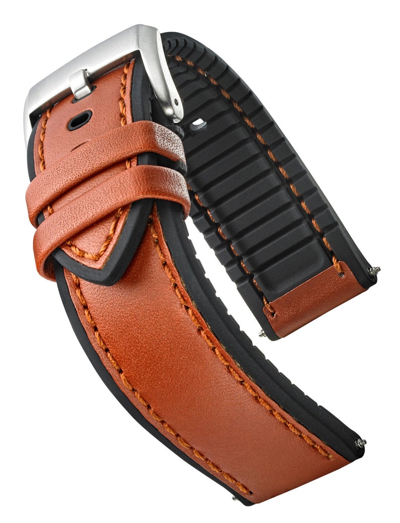 May include: A brown leather watch strap with a black rubber insert and a silver buckle.