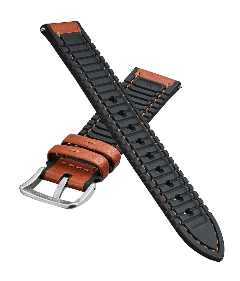 May include: A black and brown leather watch strap with orange stitching. The strap has a textured rubber design and a silver buckle.