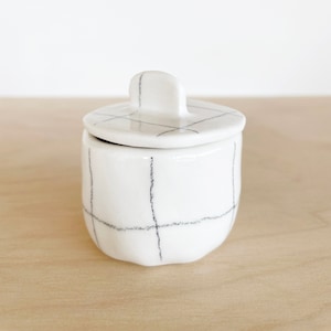 Small ceramic white porcelain pot with lid, black pencil grid pattern