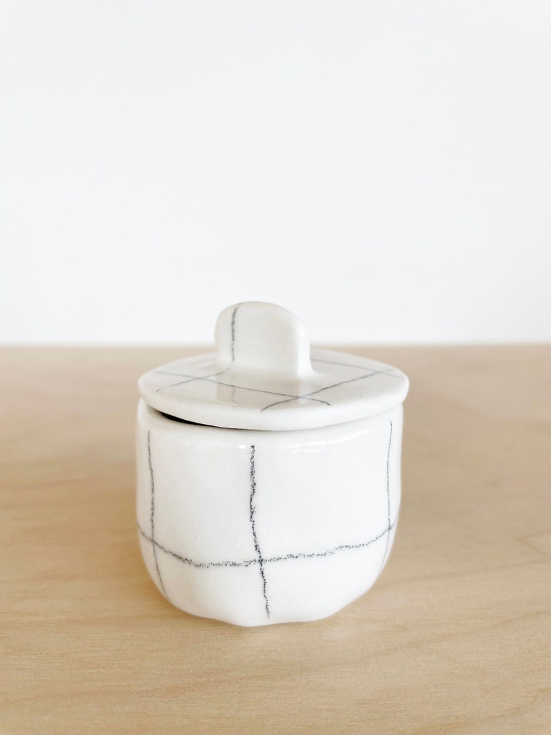 Small ceramic white porcelain pot with lid, black pencil grid pattern