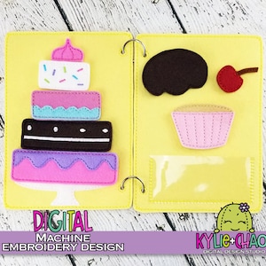 May include: A yellow felt quiet book with a layered cake, cupcake, and other felt food items. The cake has pink, white, and chocolate layers. The book is bound with metal rings. Text on the bottom reads "DIGITAL MACHINE EMBROIDERY DESIGN".