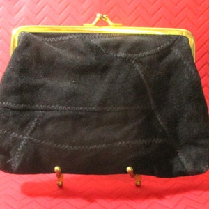 May include: A black suede coin purse with a gold metal frame and clasp.