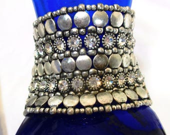 2 1/4" wide elasticized 90s bracelet: rows of silvertone beads divide rows of studs and rows of bezel set rhinestones. Estate Sale Find 2527