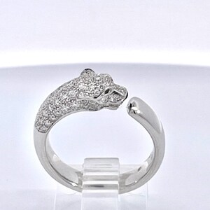 May include: A silver ring with a pave-set diamond panther head design. The ring is open on one side and has a smooth, polished band.
