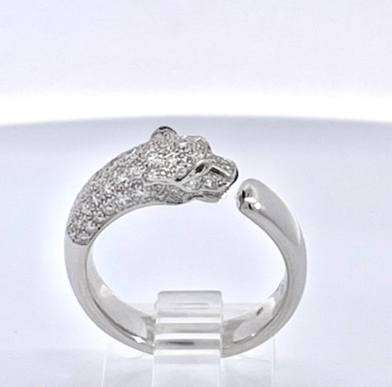 May include: A silver ring with a pave-set diamond panther head design. The ring is open on one side and has a smooth, polished band.