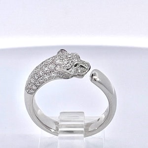 May include: A silver ring with a pave diamond panther head design.
