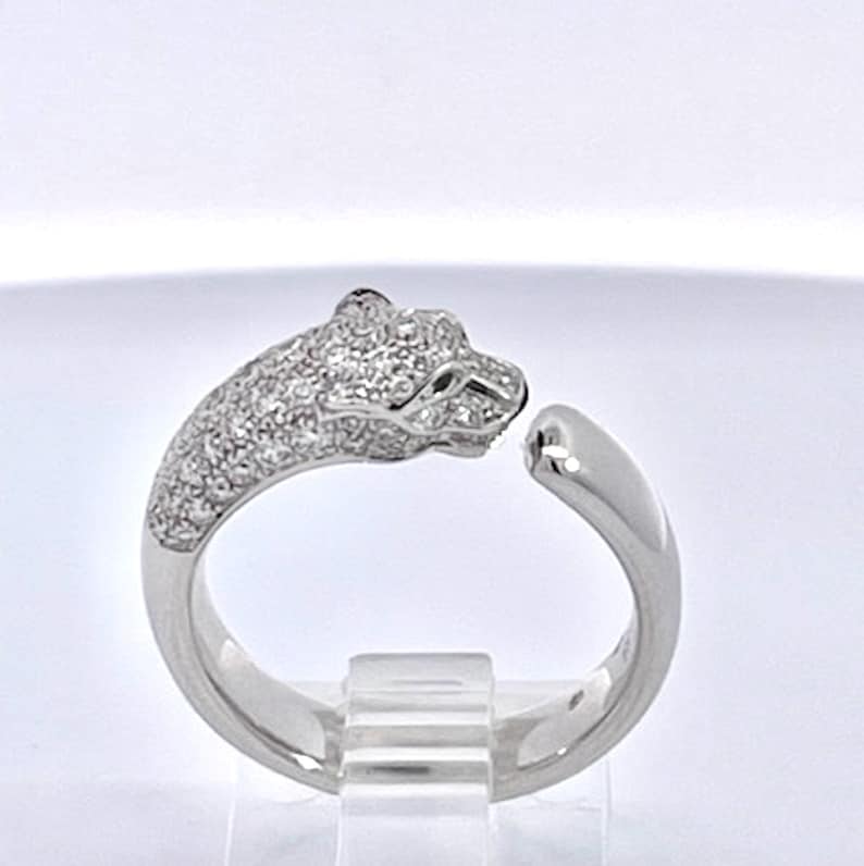 May include: A silver ring with a pave diamond panther head design.