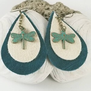 May include: Teal and cream leather teardrop earrings with a dragonfly charm.