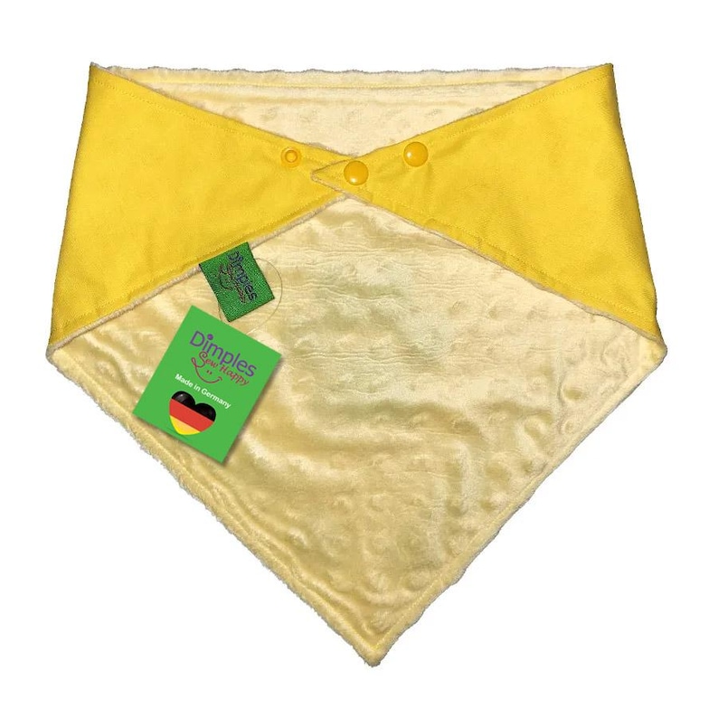 May include: A yellow baby bib with a soft, plush interior and a contrasting yellow exterior. The bib is secured with three yellow buttons and features a tag that reads "Dimples are happy" and "Made in Germany."