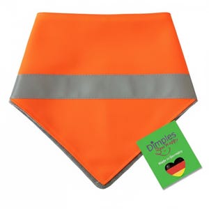 May include: Bright orange pet bandana with a reflective gray stripe. The bandana has a gray border and a green tag that reads "Dimples Sew Happy" and "Made in Germany."