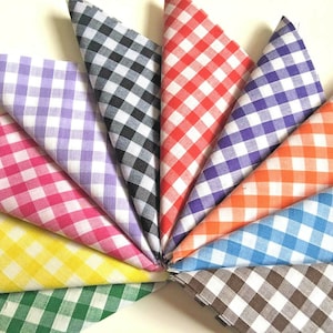 May include: A collection of ten fabric squares with a gingham pattern in various colours, including black, red, purple, orange, blue, brown, yellow, pink, green, and lavender.
