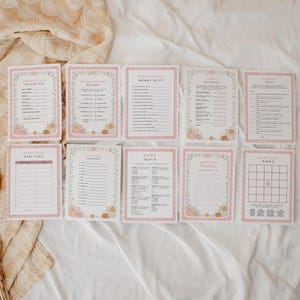 May include: A set of ten rectangular baby shower game cards with white backgrounds, pink scalloped borders, and illustrations of pumpkins and foliage. The cards feature printed text for various activities including trivia, bingo, and advice.