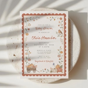 May include: A rectangular baby shower invitation card with a scalloped terracotta border. The design features watercolor illustrations of pumpkins, vines, and a small bird. Text includes: Join us for a Baby Shower in honor of Olivia Alexander, Saturday October 24, 2026 at 5:00PM, Borcelle Place 123 Honeymoon Ave Orlando, FL 12345, RSVP to Beth at 123-456-7890, Registered at Babylist.