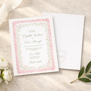May include: Wedding invitation with a pink scalloped border and floral accents. The invitation includes the names Elizabeth Williams and Olivia Harrington, along with event details. A matching envelope is next to the invitation, with a floral sprig and white flowers.