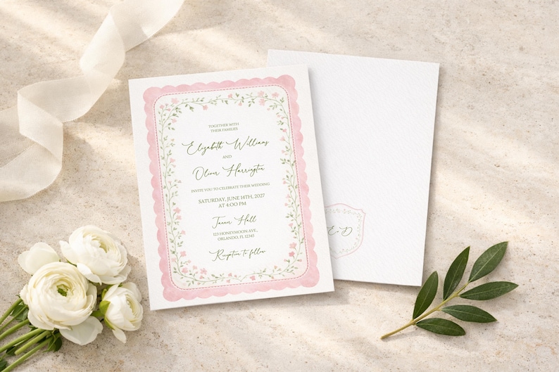 May include: Wedding invitation with a pink scalloped border and floral accents. The invitation includes the names Elizabeth Williams and Olivia Harrington, along with event details. A matching envelope is next to the invitation, with a floral sprig and white flowers.