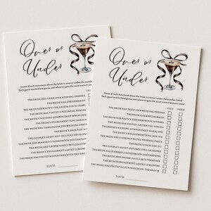 May include: Two ivory-colored Over or Under bridal shower game cards. Each card features the title in elegant script, a cocktail illustration, and a list of statements with check boxes. The cards are designed for a wedding party game.