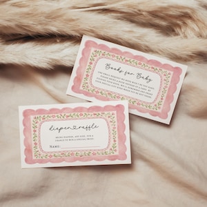 May include: Two baby shower cards with pink scalloped borders and floral accents. One card reads "Books for Baby," the other "diaper raffle." Both cards have text in a handwritten style, inviting guests to participate in the baby shower.