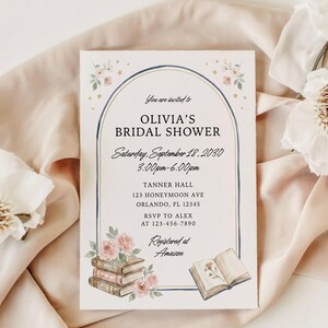 May include: A rectangular bridal shower invitation card featuring a blue arched frame, pink floral illustrations, and a stack of books. The text reads: You are invited to OLIVIA'S BRIDAL SHOWER, Saturday, September 18, 2030, 3:00pm-6:00pm, TANNER HALL, 123 HONEYMOON AVE, ORLANDO, FL 12345, RSVP TO ALEX AT 123-456-7890, Registered at Amazon.