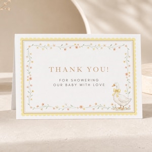 Peut inclure: Une carte de remerciement rectangulaire blanche avec une bordure festonnée jaune et un cadre de vigne florale délicat. Le texte indique THANK YOU! FOR SHOWERING OUR BABY WITH LOVE. Un canard blanc avec un nœud jaune est illustré en bas à droite.
