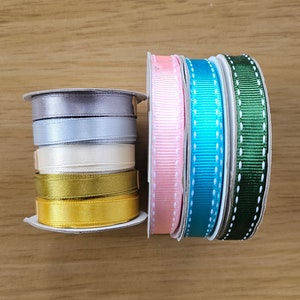 Puede incluir: Carretes de cinta de varios colores: gris, azul claro, crema, dorado, rosa, turquesa y verde. Algunas cintas son lisas, otras tienen un dise&ntilde;o de puntos. Ideal para manualidades y envolver regalos.