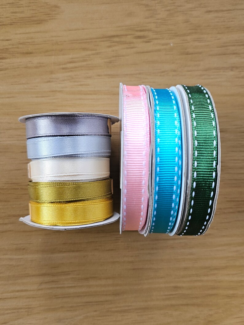 Puede incluir: Carretes de cinta de varios colores: gris, azul claro, crema, dorado, rosa, turquesa y verde. Algunas cintas son lisas, otras tienen un dise&ntilde;o de puntos. Ideal para manualidades y envolver regalos.