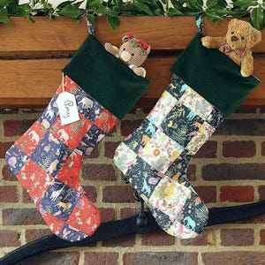 May include: Two Christmas stockings with patchwork patterns and green cuffs hang from a wooden mantel. One stocking has a tag that says "Amy". Each stocking is stuffed with a small teddy bear. The stockings are decorated with animal and floral patterns.
