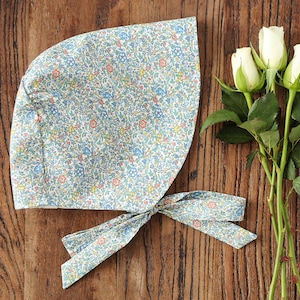 May include: A blue and white floral print bonnet with a matching tie. The bonnet is made of a soft, lightweight fabric and is perfect for keeping the sun out of your eyes.