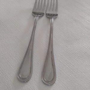 May include: Two silver forks with beaded handles.