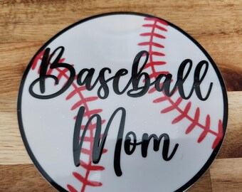 Może przedstawiać: Biała piłka baseballowa z czerwonymi szwami i napisem "Baseball Mom" w kolorze czarnym.