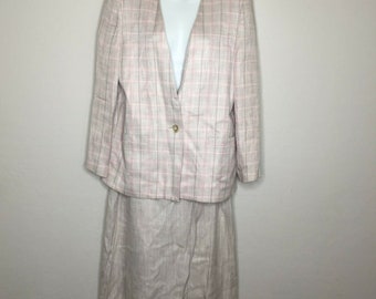 May include: A beige and pink checked skirt suit with a single button fastening on the jacket. The skirt is knee-length and the jacket has a v-neck.